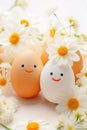 Cute handmade eggs with funny faces and spring flowers on light background. Happy Easter Royalty Free Stock Photo
