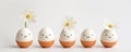 Cute handmade eggs with funny faces and spring flowers on light background. Happy Easter Royalty Free Stock Photo