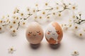 Cute handmade eggs with funny faces and spring flowers on light background. Happy Easter Royalty Free Stock Photo