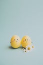 Cute handmade eggs with funny faces and spring flowers on light background. Happy Easter Royalty Free Stock Photo