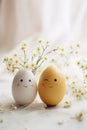 Cute handmade eggs with funny faces and spring flowers on light background. Happy Easter Royalty Free Stock Photo