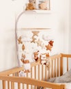 Cute handmade felt mobile on the crib for children. Brown and white colors. Bear, owl, deer, sheep, hedgehog and stars