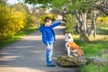 Cute handsome stylish boy enjoying colourful autumn park with his best friend red and white english bull dog.Delightfull