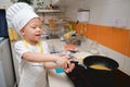 Cute happy Asian boy having fun cooking breakfast in kitchen, Fun indoor activities for kindergarten kids, Stay home Stay safe Royalty Free Stock Photo