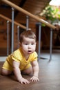 Cute happy baby boy crawling on the floor indoors, standing on knees Royalty Free Stock Photo