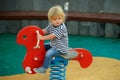 Cute happy baby boy riding red spring rider Royalty Free Stock Photo