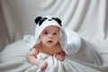Cute happy baby boy in soft bathrobe after bath playing on white bed. Child in clean and dry towel. Wash, infant hygiene Royalty Free Stock Photo