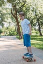 cute happy boy riding skateboard and smiling at camera Royalty Free Stock Photo