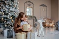 Cute happy boy in santa hat unwrap christmas present box on holiday morning in beautiful room interior. Male child open Xmas gifts Royalty Free Stock Photo