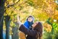 Cute, happy, boy smiling and hugging with his mom among yellow l Royalty Free Stock Photo