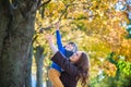 Cute, happy, boy smiling and hugging with his mom among yellow leaves. Little child having fun with mother in autumn park. Concept Royalty Free Stock Photo