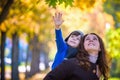 Cute, happy, boy smiling and hugging with his mom among yellow leaves. Little child having fun with mother in autumn park. Concept Royalty Free Stock Photo