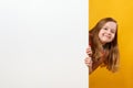 Cute happy cheerful little girl holding a blank white space banner on a yellow background Royalty Free Stock Photo