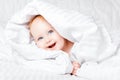 Cute and Happy child with blue eyes looking out of the white blanket. Copy space.