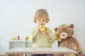 Cute happy child boy having fun eating a big fresh yellow apple fruit at home. Children healthy eating and lifestyle conceptual Royalty Free Stock Photo