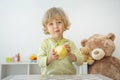 Cute happy child boy having fun eating a big fresh yellow apple fruit at home. Children healthy eating and lifestyle conceptual Royalty Free Stock Photo