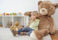 Cute happy child boy sitting on his giant teddy bear and eating a fresh yellow apple fruit. Children healthy eating and lifestyle Royalty Free Stock Photo