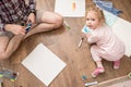 Cute, happy child draws with colored markers on white paper, sitting on the floor, next to his father. Lifestyle. Royalty Free Stock Photo