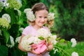 Cute happy child girl with hydrangea flowers bouquet in summer garden Royalty Free Stock Photo