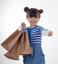 Cute happy child holding discount white card and shopping bags in her hands. Kid with credit card. Little girl showing empty cou Royalty Free Stock Photo