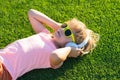 Cute and happy child 7-8 years old lying on the grass and listening to music in headphones on a sunny summer day, Royalty Free Stock Photo