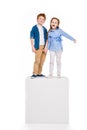 cute happy children standing on white cube and smiling at camera Royalty Free Stock Photo