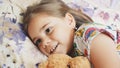 Cute happy emotional child girl lying in a bed and smilling. Royalty Free Stock Photo