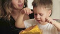 Cute, happy, excited mom and son unwrap the gift box.