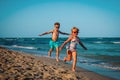 Cute happy girl and boy running on beach Royalty Free Stock Photo