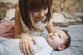 Cute happy girl holding her newborn baby brother. Gray background. Pretty baby boy in blue clothes Royalty Free Stock Photo