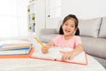 Cute happy girl kid student writing studying book