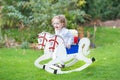 Cute happy girl on rocking horse in the garden Royalty Free Stock Photo