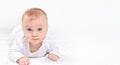 Cute happy healthy caucasian baby lying on stomack on a white blanket looking at camera.Banner copy space for text