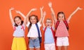 Cute happy kids classmates cheering together with hands in air, having fun after school