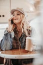Cute happy lady talking by phone in bus cafe Royalty Free Stock Photo
