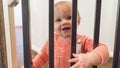 Cute happy little baby peering through rails Royalty Free Stock Photo