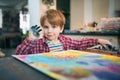 Cute happy little boy, adorable preschooler, painting in a sunny art studio. Young artist at work Royalty Free Stock Photo