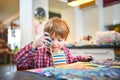 Cute happy little boy, adorable preschooler, painting in a sunny art studio. Young artist at work Royalty Free Stock Photo