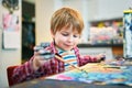 Cute happy little boy, adorable preschooler, painting in a sunny art studio. Young artist at work Royalty Free Stock Photo