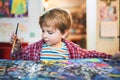 Cute happy little boy, adorable preschooler, painting in a sunny art studio. Young artist at work Royalty Free Stock Photo