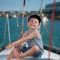 Cute happy little boy in captain`s cap travels on luxury boat Royalty Free Stock Photo