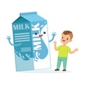 Cute happy little boy and funny milk carton box with smiling human face playing and having fun, healthy childrens food Royalty Free Stock Photo