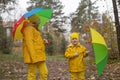 Cute happy little boy and a girl - brother and sister - in identical yellow costumes and hats walking in the forest with rainbow- Royalty Free Stock Photo