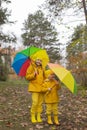 Cute happy little boy and a girl - brother and sister - in identical yellow costumes and hats walking in the forest with rainbow- Royalty Free Stock Photo