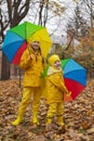 Cute happy little boy and a girl - brother and sister - in identical yellow costumes and hats walking in the forest with rainbow- Royalty Free Stock Photo