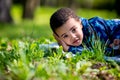 Cute happy little boy lying in green grass on spring Royalty Free Stock Photo