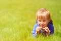Cute happy little boy lying in green grass on spring Royalty Free Stock Photo