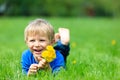 Cute happy little boy lying in green grass on spring Royalty Free Stock Photo