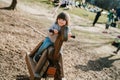 Cute happy little boy riding wooden horse toy on playground outdoors Royalty Free Stock Photo