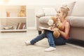 Happy little female child and her teddy bear reading book on the floor at home Royalty Free Stock Photo